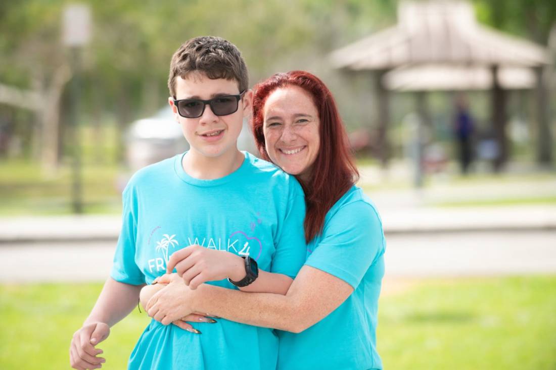 A teen and his mother hugging and smiling at Walk4Friendship